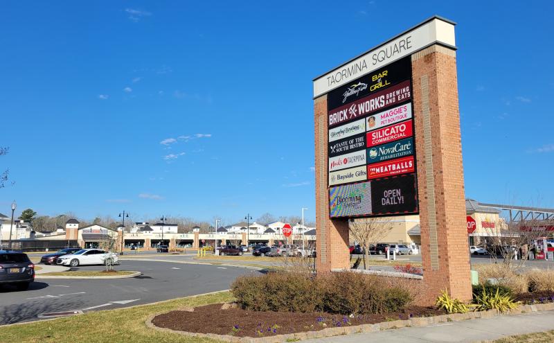 sign showing the names for all the stores in the shopping center on a clear skies day